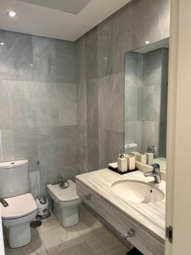 a bathroom with a sink and a toilet and a mirror at Balcón de la Cala in Estepona