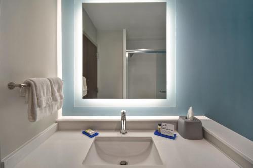 a bathroom with a sink and a mirror at Holiday Inn Express & Suites - Galveston Beach by IHG in Galveston