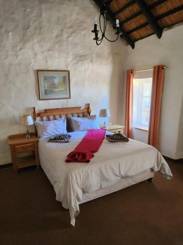 a bedroom with a large bed and a window at Gooderson Leisure Mountain View Cottages Self Catering Resort in Drakensberg Garden