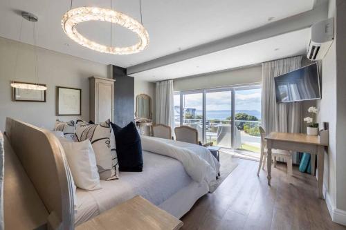 a bedroom with a large bed and a table with chairs at Hermanus Boutique Guest House in Hermanus