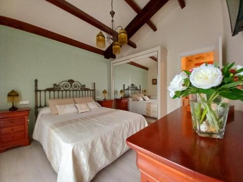 a bedroom with a bed and a vase of flowers on a table at Casa Xan in Jove