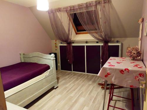 ein kleines Schlafzimmer mit einem Bett und einem Tisch in der Unterkunft Maison de 4 chambres avec jardin clos et wifi a Roncherolles en Bray in Mauquenchy