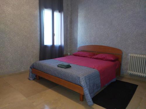 1 dormitorio con cama con sábanas rosas y ventana en Stunning 3-Bed House in San Zenone degli Ezzelini, en San Zenone