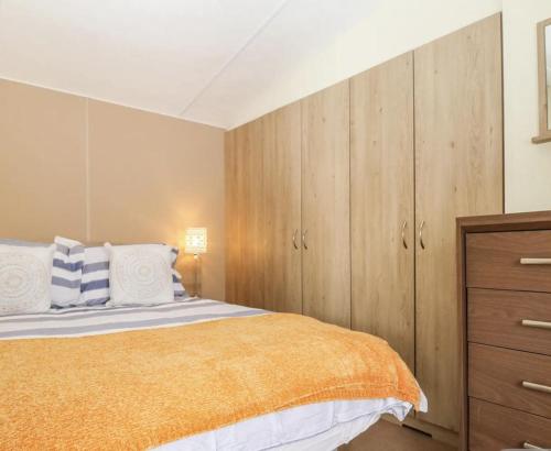 een slaapkamer met een bed en houten kasten bij Charming and peaceful 2-Bed Chalet in Hampshire in Warsash