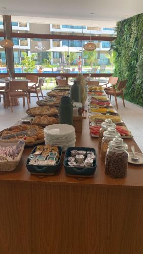 ein Buffet mit Speisen auf einem Tisch in einem Gebäude in der Unterkunft Mana Beach Muro Alto-Flat 12 Ohana e 20 Aloha Térreo Frente Piscina in Porto De Galinhas