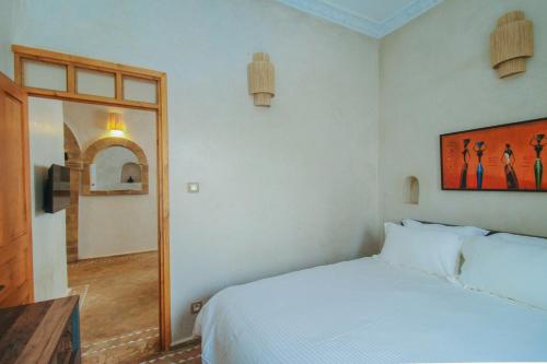 エッサウィラにあるStella 1 - joli appartement en médina avec cheminéeのベッドルーム(白いベッド1台、鏡付)