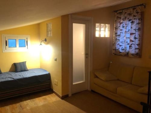 a bedroom with a bed and a couch and a window at La Casa nella Pineta in Fiuggi