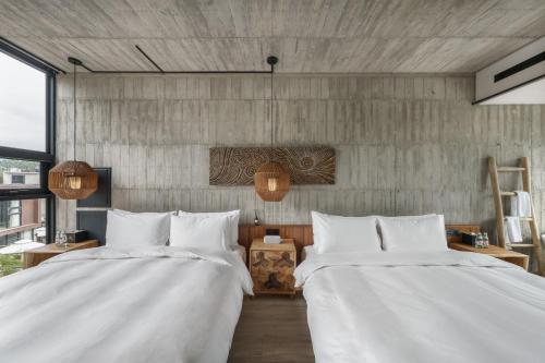 two beds in a room with white sheets at Deer Chaser Hotel in Yuchi