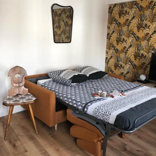 - une chambre avec un lit, une chaise et un réveil dans l'établissement Abbaye aux hommes, un charmant cocon pour 2,3 ou 4!, à Caen