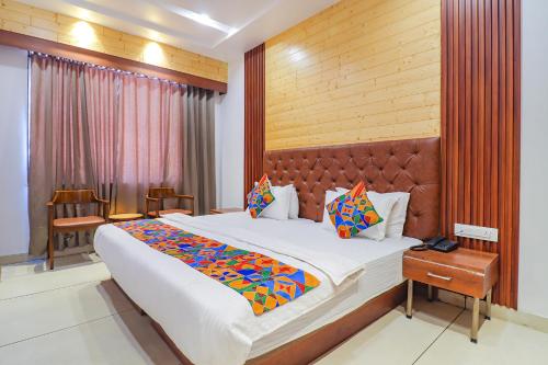 um quarto com uma cama grande e uma parede de madeira em FabHotel Grand Arya em Patna