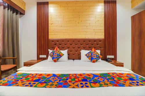 1 dormitorio con 1 cama grande y colcha colorida en FabHotel Grand Arya en Patna