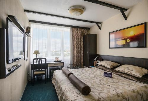 a hotel room with a bed with a desk and a window at River Park in Novosibirsk