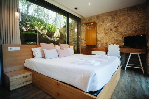 a bedroom with a large bed and a desk at Quinta do Pomar Maior in Arouca