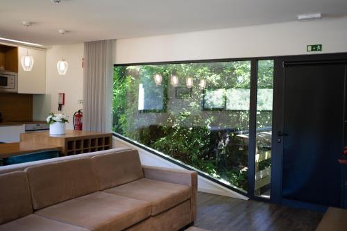 a living room with a couch and a large window at Quinta do Pomar Maior in Arouca