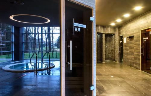 a lobby with a large glass door with a fountain at MEDEA Apartments by UPA in Druskininkai