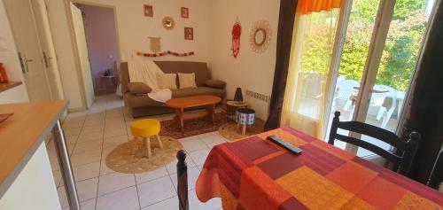 un salon avec une table et un canapé dans l'établissement Petite maison au calme garrigue et mer Montpellier, à Teyran