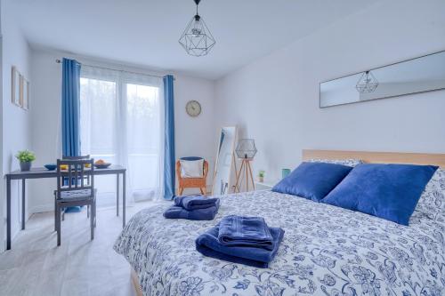 um quarto com uma cama com almofadas azuis em LOGEMENT AARON em Courcouronnes