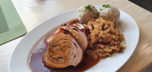 a plate of food with meat and potatoes on a table at Hotel zur Post in Lam