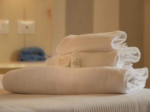 a pile of towels sitting on top of a bed at Hotel La Smorfia in Castiglioncello