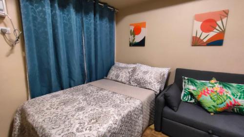 ein kleines Schlafzimmer mit einem Bett und einer Couch in der Unterkunft Fully furnished Studio unit in Avida Aspira Tower 1 in Cagayan de Oro