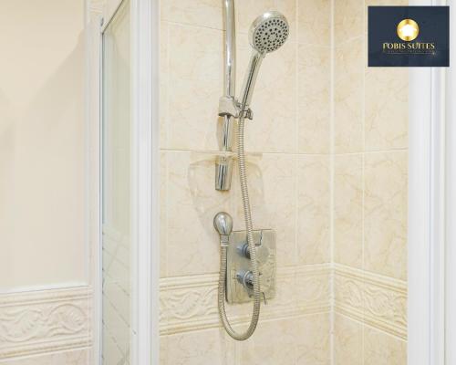 a shower with a shower head in a bathroom at 4 Bed Monthly Discount Family Contractors Business By Fobis Suites Short Lets & Serviced Accommodation Hatfield in Hatfield