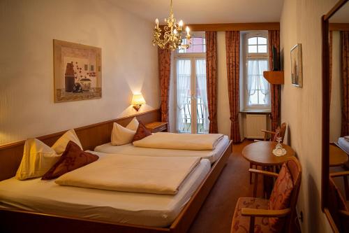 a hotel room with two beds and a chandelier at Nostalgie Altstadt Hotel Kornpforte by 42 in Koblenz