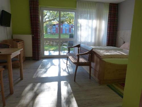 a bedroom with a bed and a table and a window at Gästehaus Steker in Bad Driburg
