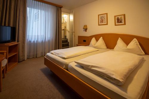 a hotel room with a bed with a television and a bed sidx sidx at Nostalgie Altstadt Hotel Kornpforte by 42 in Koblenz