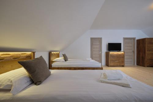a bedroom with two beds and a flat screen tv at Jonavos alpakų svečių namai in Jonava