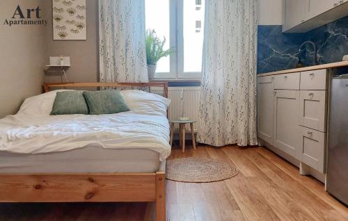 - une petite chambre avec un lit et une fenêtre dans l'établissement Art Apartamenty 1, à Kalisz