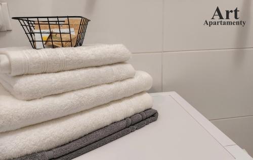 - une pile de serviettes assises sur une table dans la salle de bains dans l'établissement Art Apartamenty 1, à Kalisz