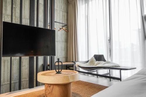 a living room with a television and a chair at Deer Chaser Hotel in Yuchi