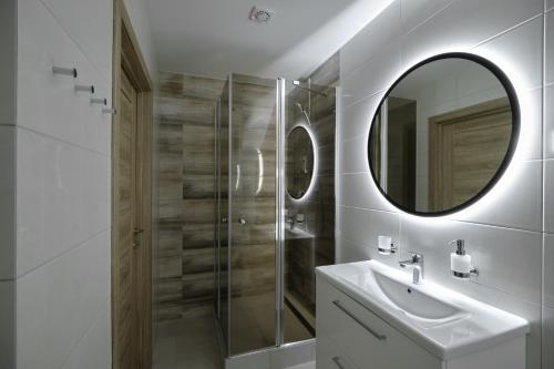 a white bathroom with a sink and a mirror at Jonavos alpakų svečių namai in Jonava
