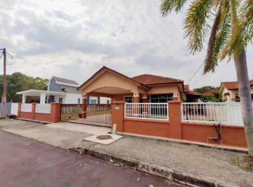 a house with a fence in front of a street at Villa Mikayla Homestay - Alor Setar in Alor Setar