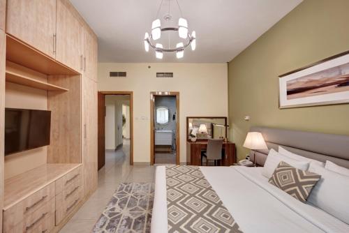 - une chambre avec un grand lit et un lustre dans l'établissement Radiance Premium Suites, à Dubaï