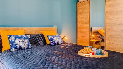 um quarto com uma cama com uma bandeja de comida em Apartment Przyfabryczny Księży Młyn - Garaż - Klimatyzacja - FV em Lódź