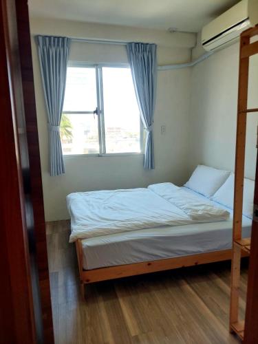 a bed in a room with a window at 未見海 in Tainan