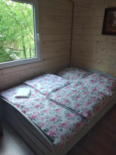 a bed in a room with a window at Agroturystyka u Wioli i Irka , domek u Ireny, spływy kajakowe in Karsin