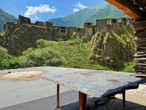 a stone bench in front of a castle on a mountain at Ethnic Hostel Shatili in Shatili
