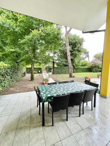 a green table and chairs on a patio at Fantastic Villa with pool for 7 guests on Albarella in Palazzo Vianello
