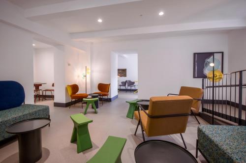 a waiting room with colorful chairs and tables at Hotel Rural O Cruce do Burgo in Friol