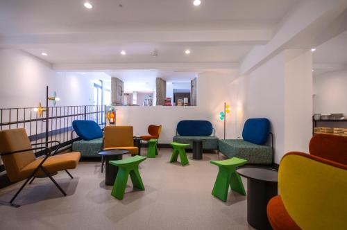a waiting room with colorful chairs and tables at Hotel Rural O Cruce do Burgo in Friol