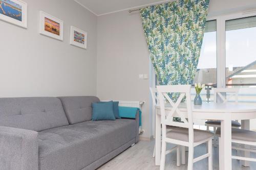a living room with a couch and a table at DreamHouse Apartament „PIASKOWY” ul. Północna 18 C, Darłówko Wschodnie in Darłówko