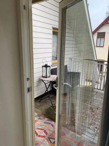 una puerta corredera de cristal que da a un balcón con mesa en Mysigt rum i villa med egen ingång och nära havet. en Åhus