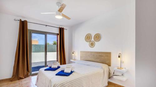 Un dormitorio con una cama con toallas azules. en Villa Jarcia by Calima Villas, en Caleta de Fuste