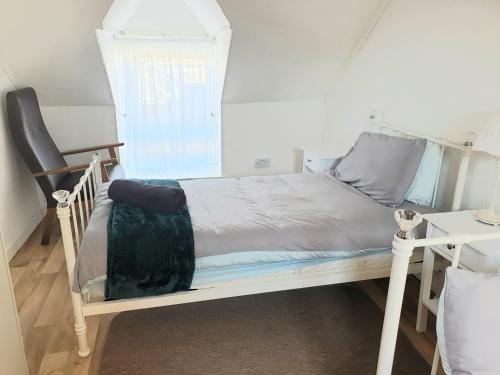 a bedroom with a white bed and a desk at Teach Eoin in Dingle