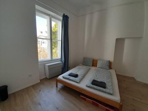 a bedroom with a bed and a large window at Sunny rooms at Danube in Budapest