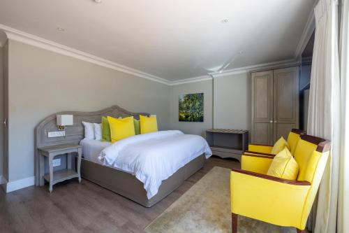 a bedroom with a large bed with yellow pillows at Hermanus Boutique Guest House in Hermanus