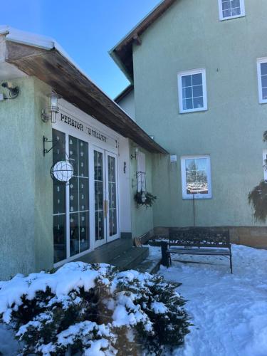 a front door of a house with snow on the ground at U Vaclava in Hřensko