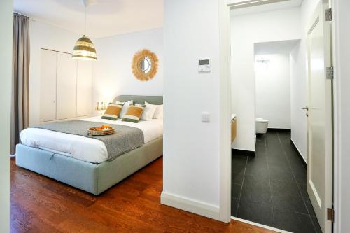 a white bedroom with a bed and a bathroom at Coast Guard Apartment in Faro